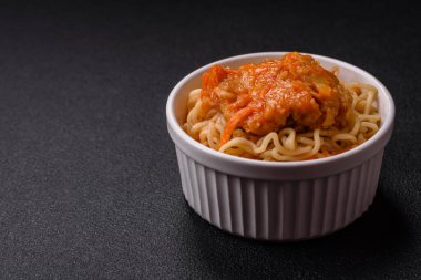 Koyu beton arka planda balık ve soslu pirinç eriştesi, tuz ve baharat.