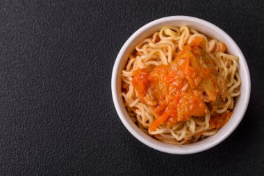 Koyu beton arka planda balık ve soslu pirinç eriştesi, tuz ve baharat.