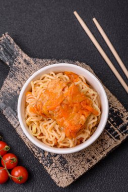 Koyu beton arka planda balık ve soslu pirinç eriştesi, tuz ve baharat.