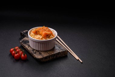 Koyu beton arka planda balık ve soslu pirinç eriştesi, tuz ve baharat.