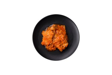 Beyaz arka planda tuz ve baharatla domates soslu dilimlenmiş balık.