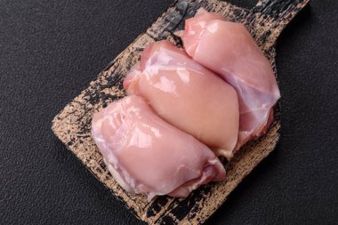 Koyu beton bir masada baharat ve otlarla taze tavuk filetosu. Et yemekleri için hazırlık.