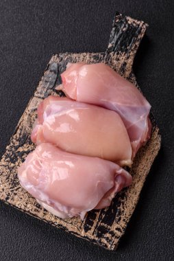 Koyu beton bir masada baharat ve otlarla taze tavuk filetosu. Et yemekleri için hazırlık.