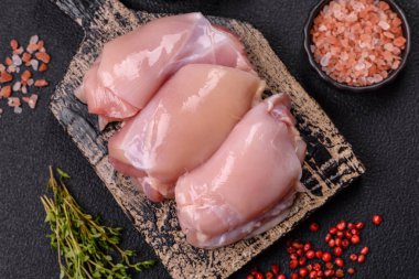 Koyu beton bir masada baharat ve otlarla taze tavuk filetosu. Et yemekleri için hazırlık.