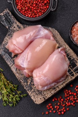 Koyu beton bir masada baharat ve otlarla taze tavuk filetosu. Et yemekleri için hazırlık.