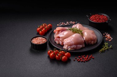 Koyu beton bir masada baharat ve otlarla taze tavuk filetosu. Et yemekleri için hazırlık.