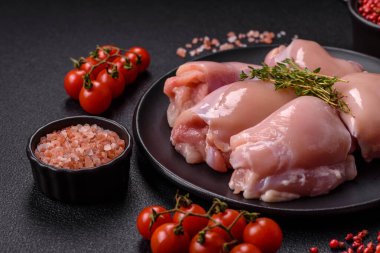 Koyu beton bir masada baharat ve otlarla taze tavuk filetosu. Et yemekleri için hazırlık.