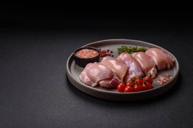 Koyu beton bir masada baharat ve otlarla taze tavuk filetosu. Et yemekleri için hazırlık.