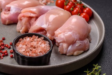 Koyu beton bir masada baharat ve otlarla taze tavuk filetosu. Et yemekleri için hazırlık.