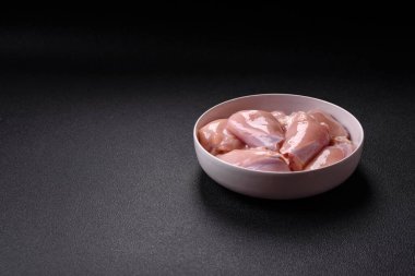 Koyu beton bir masada baharat ve otlarla taze tavuk filetosu. Et yemekleri için hazırlık.