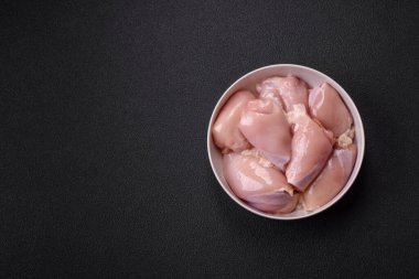 Koyu beton bir masada baharat ve otlarla taze tavuk filetosu. Et yemekleri için hazırlık.