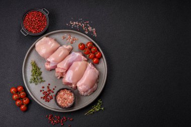 Koyu beton bir masada baharat ve otlarla taze tavuk filetosu. Et yemekleri için hazırlık.