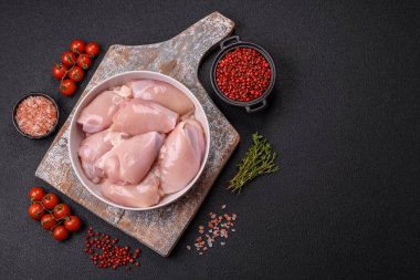 Koyu beton bir masada baharat ve otlarla taze tavuk filetosu. Et yemekleri için hazırlık.
