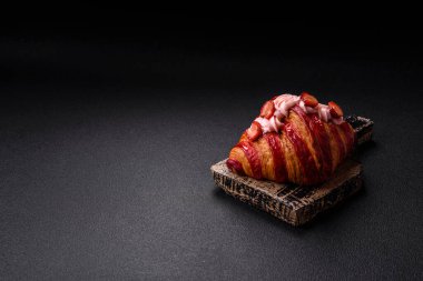 Koyu beton arka planda çilekli çıtır kırmızı kruvasan.