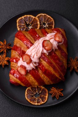 Koyu beton arka planda çilekli çıtır kırmızı kruvasan.