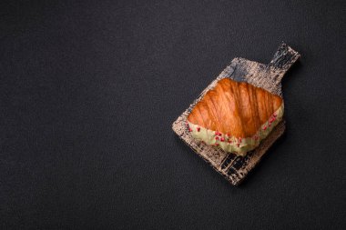 Fıstıklı, ahududulu ve koyu beton kaplamalı çıtır kırmızı kruvasan.