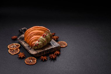 Fıstıklı, ahududulu ve koyu beton kaplamalı çıtır kırmızı kruvasan.