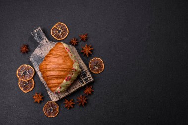 Fıstıklı, ahududulu ve koyu beton kaplamalı çıtır kırmızı kruvasan.