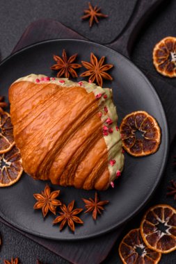 Fıstıklı, ahududulu ve koyu beton kaplamalı çıtır kırmızı kruvasan.