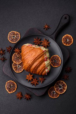 Fıstıklı, ahududulu ve koyu beton kaplamalı çıtır kırmızı kruvasan.