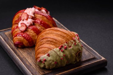 Fıstıklı, ahududulu ve koyu beton kaplamalı çıtır kırmızı kruvasan.