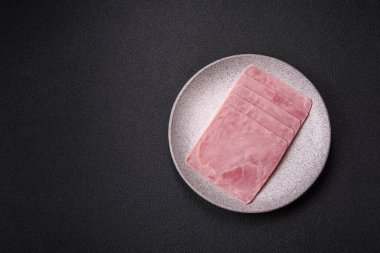 Jambon, sağlıklı bir kahvaltı için lezzetli sandviçler yapmak için dilimlere bölünmüş.