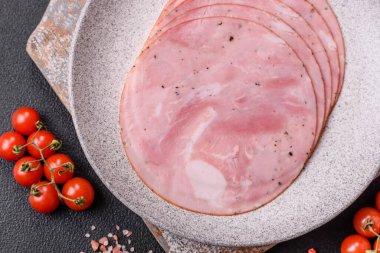 Koyu dokulu arka planda tuz, baharat ve otlarla dilimlenmiş jambon.