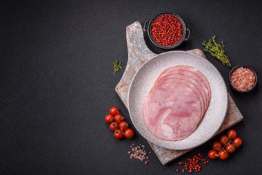 Koyu dokulu arka planda tuz, baharat ve otlarla dilimlenmiş jambon.