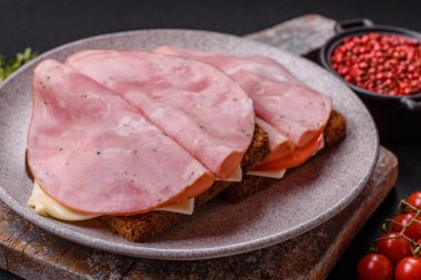 Tost, jambon, peynir, domates, tuz, baharat ve otlu sandviç.