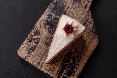 Üzerinde hindistancevizi serpiştirilmiş ahududu reçeli, koyu beton kaplama tatlı bir pasta.