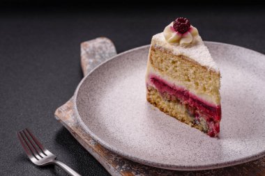 Üzerinde hindistancevizi serpiştirilmiş ahududu reçeli, koyu beton kaplama tatlı bir pasta.