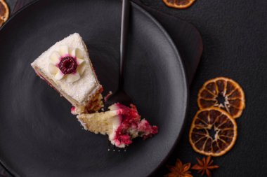 Üzerinde hindistancevizi serpiştirilmiş ahududu reçeli, koyu beton kaplama tatlı bir pasta.