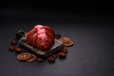 Koyu beton arka planda kremalı ve çilekli taze kırmızı kruvasan.