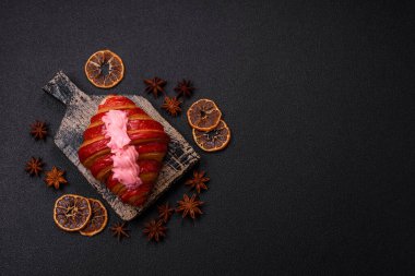 Koyu beton arka planda kremalı ve çilekli taze kırmızı kruvasan.