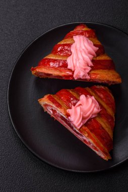 Koyu beton arka planda kremalı ve çilekli taze kırmızı kruvasan.