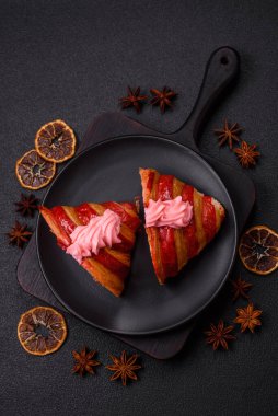 Koyu beton arka planda kremalı ve çilekli taze kırmızı kruvasan.