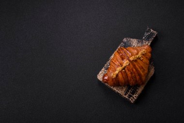 Koyu beton arka planda fıstıklı kremayla dolu taze kruvasan.