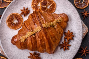 Koyu beton arka planda fıstıklı kremayla dolu taze kruvasan.