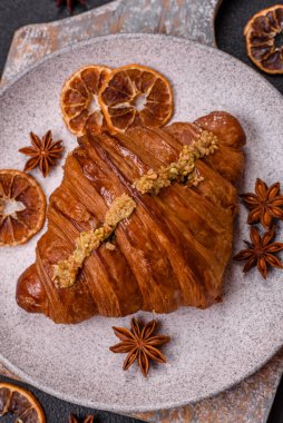 Koyu beton arka planda fıstıklı kremayla dolu taze kruvasan.