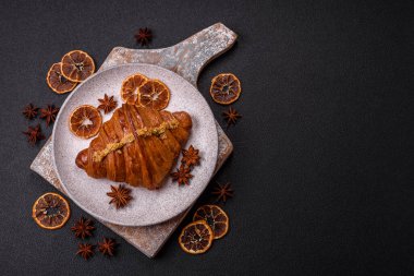 Koyu beton arka planda fıstıklı kremayla dolu taze kruvasan.