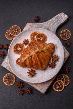 Koyu beton arka planda fıstıklı kremayla dolu taze kruvasan.