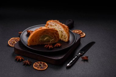 Koyu beton arka planda fıstıklı kremayla dolu taze kruvasan.