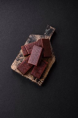 Koyu beton arka planda kremalı ve waffle 'lı dikdörtgen çikolatalı şekerler.