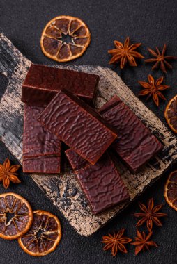 Koyu beton arka planda kremalı ve waffle 'lı dikdörtgen çikolatalı şekerler.