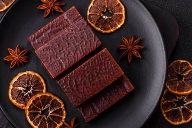 Koyu beton arka planda kremalı ve waffle 'lı dikdörtgen çikolatalı şekerler.