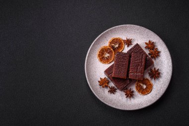 Koyu beton arka planda kremalı ve waffle 'lı dikdörtgen çikolatalı şekerler.