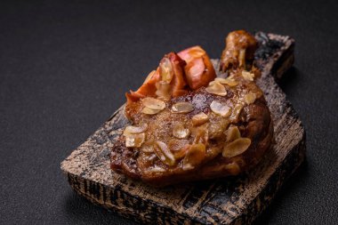 Koyu beton arka planda elma ve sos ile pişirilmiş ördek bacağı.