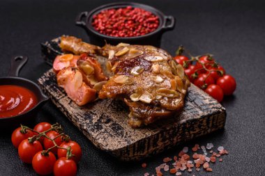 Koyu beton arka planda elma ve sos ile pişirilmiş ördek bacağı.