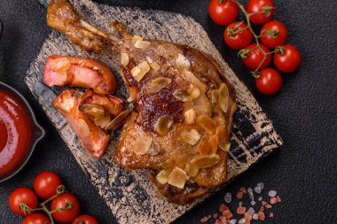 Koyu beton arka planda elma ve sos ile pişirilmiş ördek bacağı.