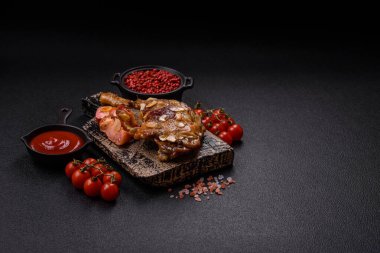 Koyu beton arka planda elma ve sos ile pişirilmiş ördek bacağı.